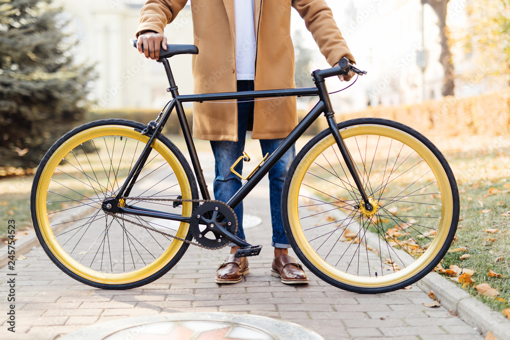 Naklejka premium Ready to ride. Close-up of young man sitting on his bicycle outdoors
