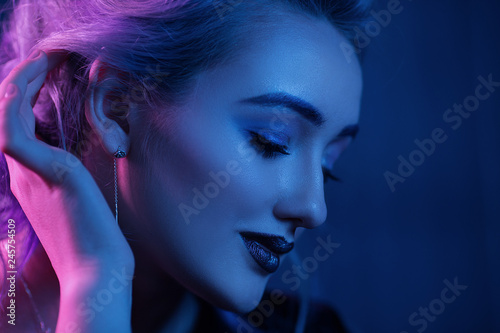 Fototapeta Naklejka Na Ścianę i Meble -  Beautiful woman with night makeup touching her hair. Close-up