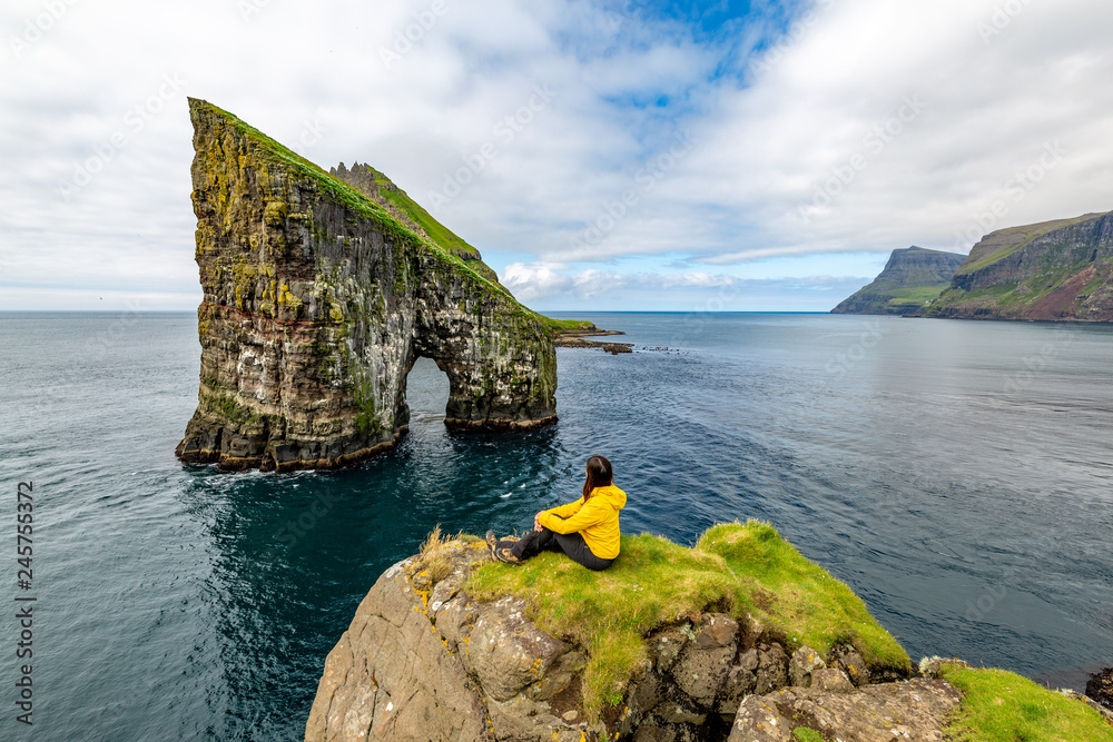 Drangarnir rocks at Faroe Islands, Europe. Hiker admiring the view
