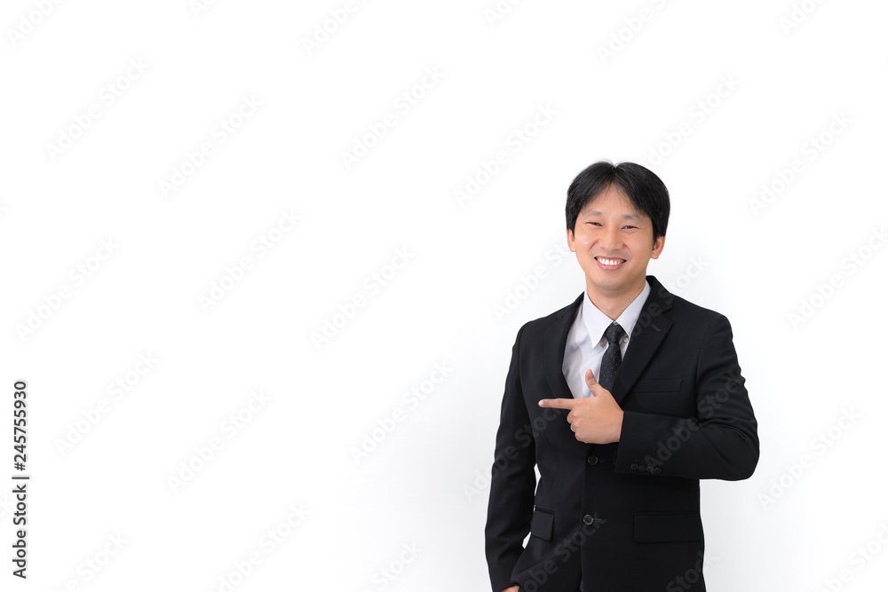 Close up portrait of Asian young handsome business man wearing suit with tie is smiling and pointing on a copyspace with his finger on the white background Close up portrait of Asian young handsome business man wearing suit with tie is smiling and pointing on a copyspace with his finger on the white background