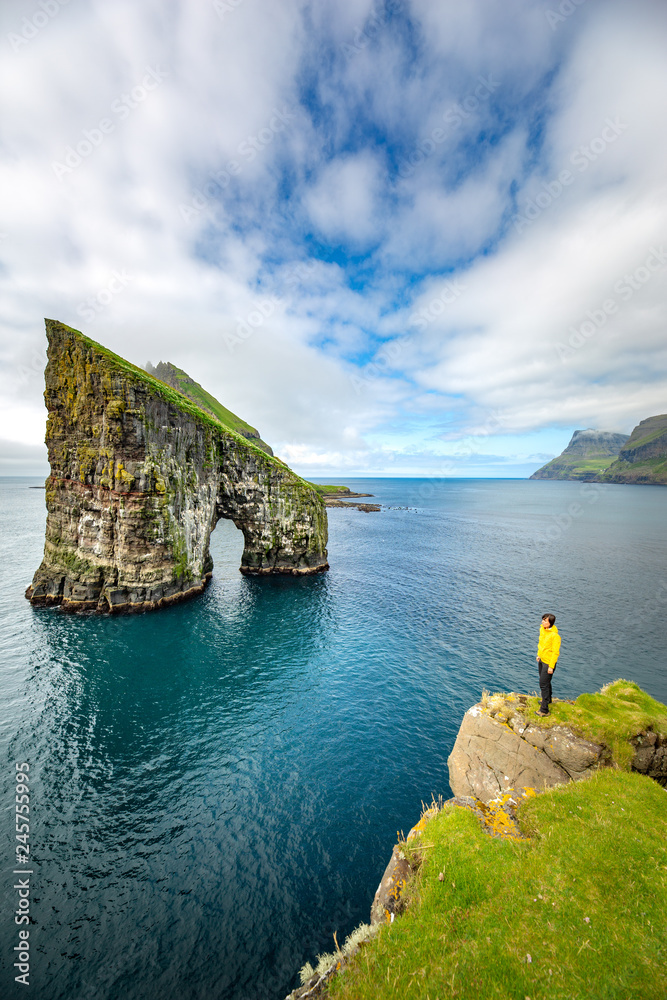 Drangarnir rocks at Faroe Islands, Europe. Hiker admiring the view