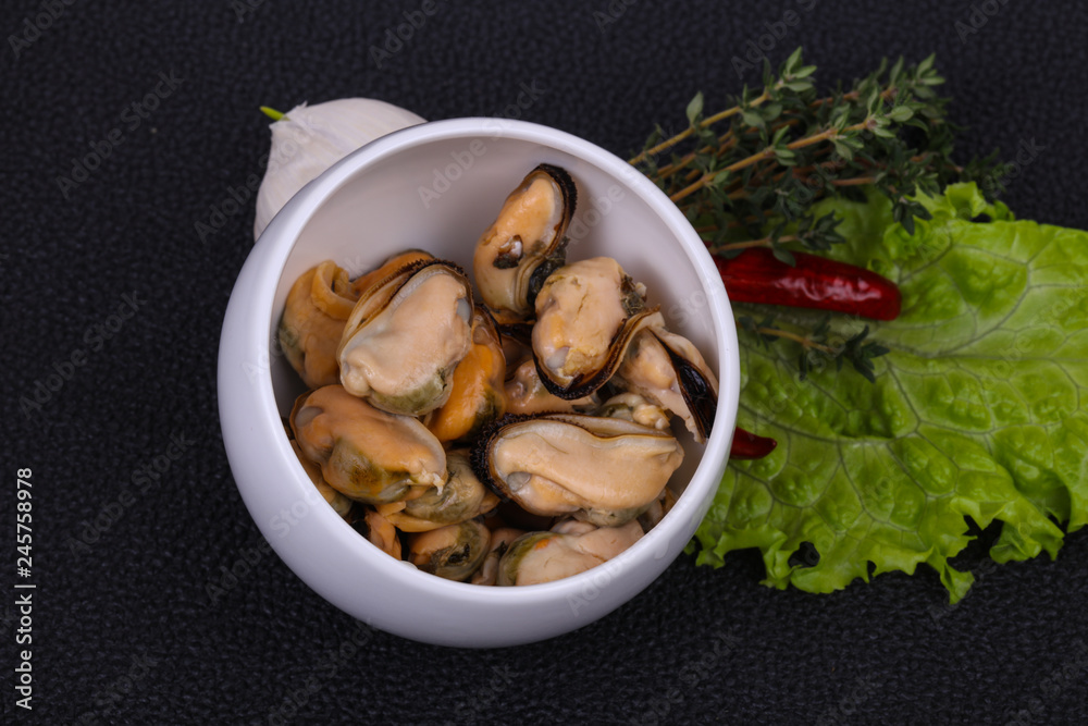 Pickled mussels in the bowl served pepper, garlic and salad Pickled mussels in the bowl served pepper, garlic and salad