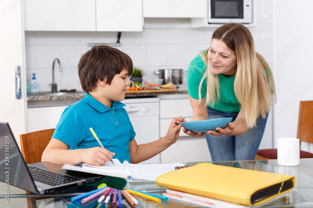 Obraz premium Mother serving breakfast to son