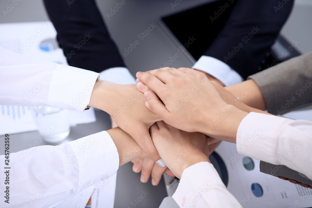 Business people group joining hands and representing concept of friendship and teamwork. Meeting of success team Business people group joining hands and representing concept of friendship and teamwork. Meeting of success team