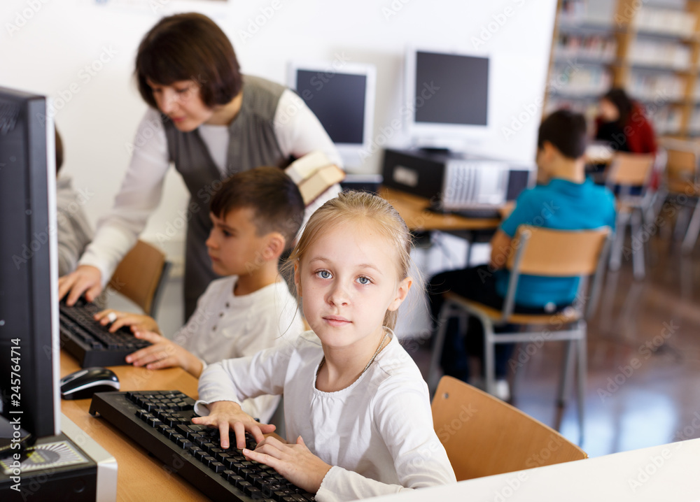 Fototapeta premium Preteen girl studying in computer class