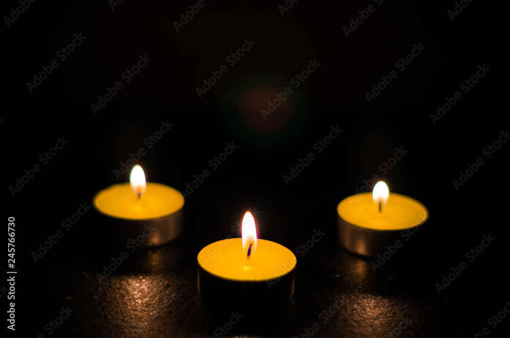 Three burning candles isolated on black background. Three burning candles isolated on black background.