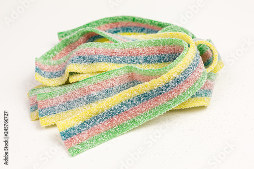 heap of striped gummy candy in blue, green, red and yellow