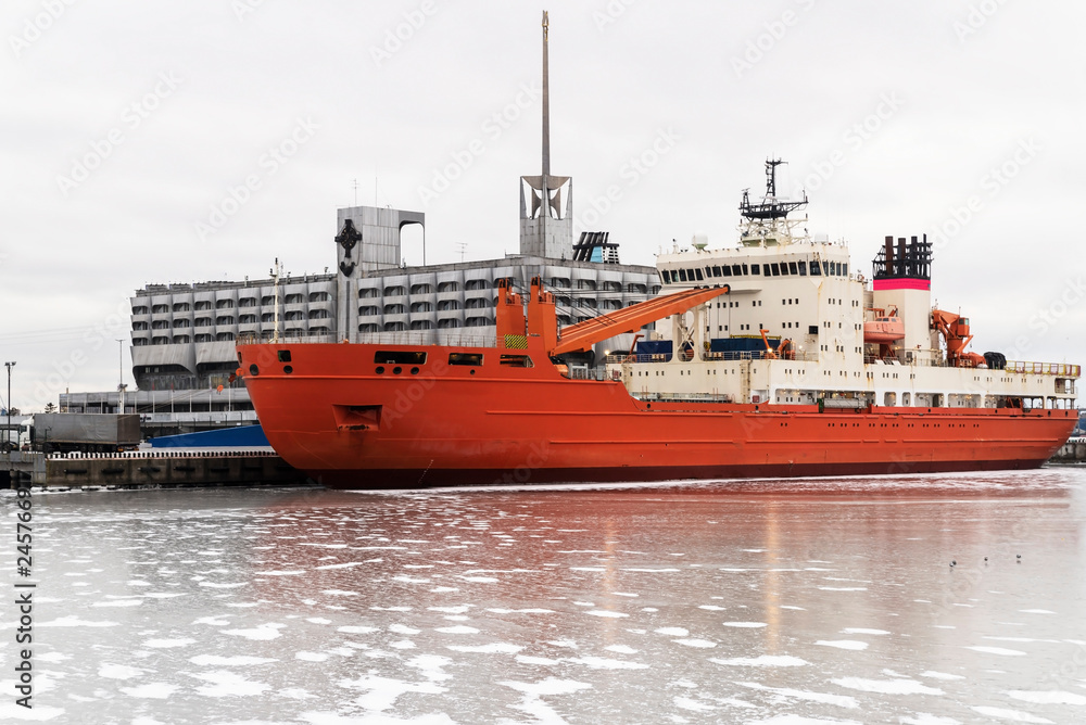 Fototapeta premium Large cargo ship in the port. Winter parking of the ship on the pier.