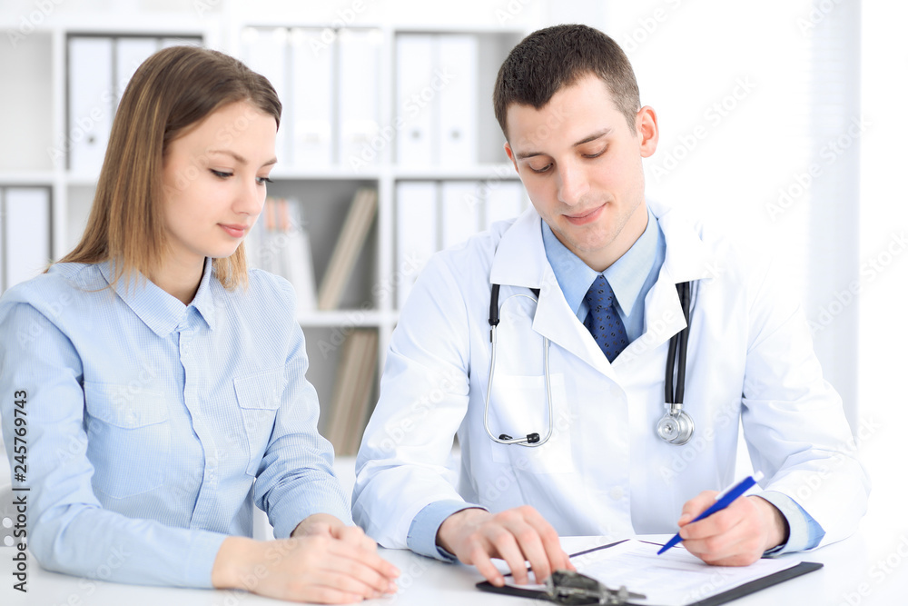 Doctor and patient sitting at the desk. Medicine and health care concept Doctor and patient sitting at the desk. Medicine and health care concept