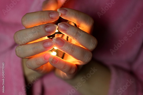 In women's hands holding glowing yellow garlands with yellow light as a symbol of light, love, religion, pray concept