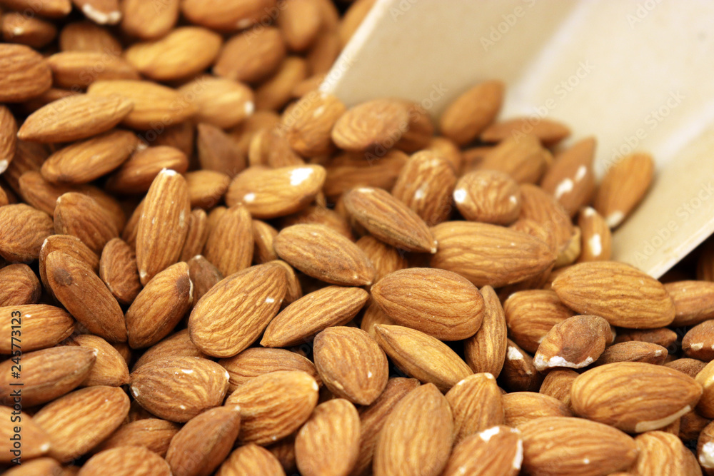 Almond nuts and scoop, selective focus. Raw almonds on the market Almond nuts and scoop, selective focus. Raw almonds on the market