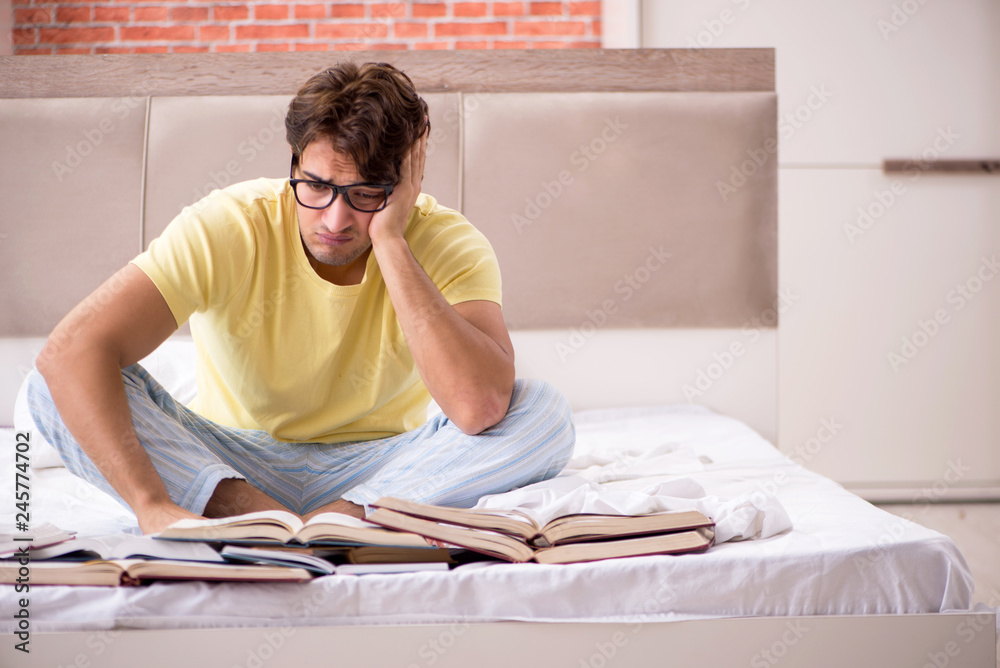 Young student studying in bed for exams Young student studying in bed for exams