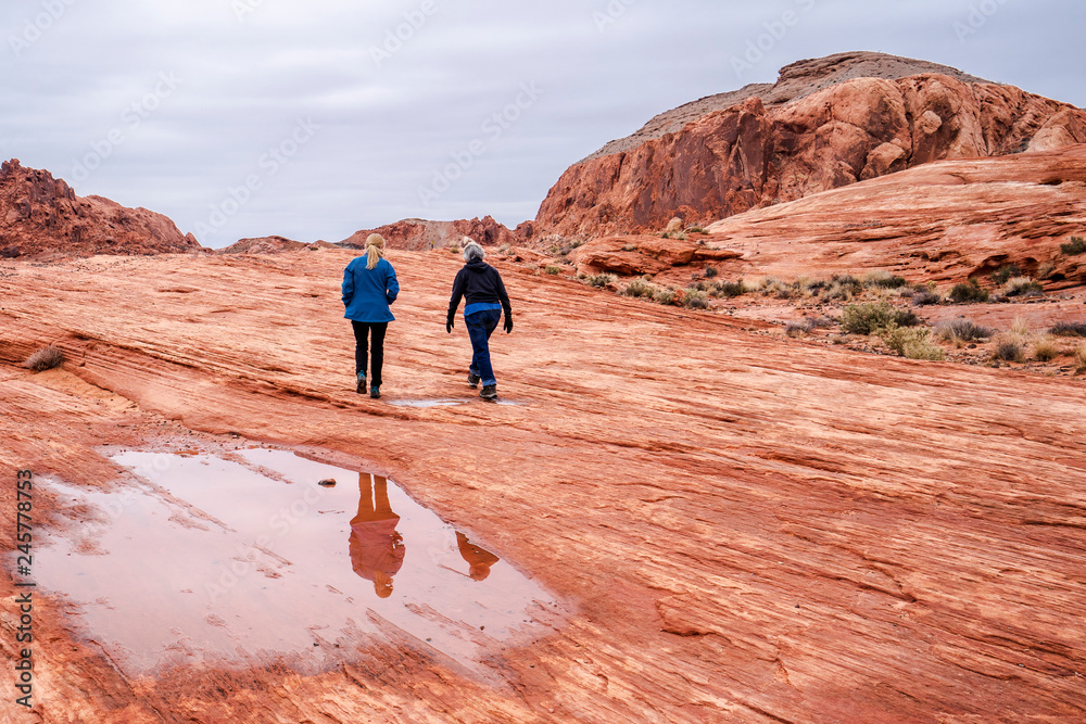 Hikers reflected in the puddle in the Valley of Fire