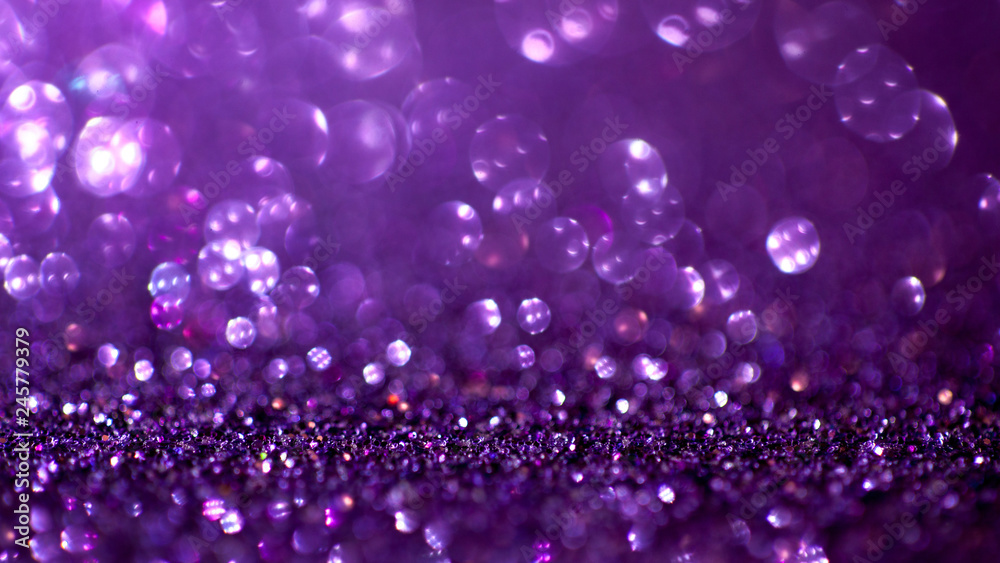 Purple glitter magic background. Defocused light and free focused place for your design.
