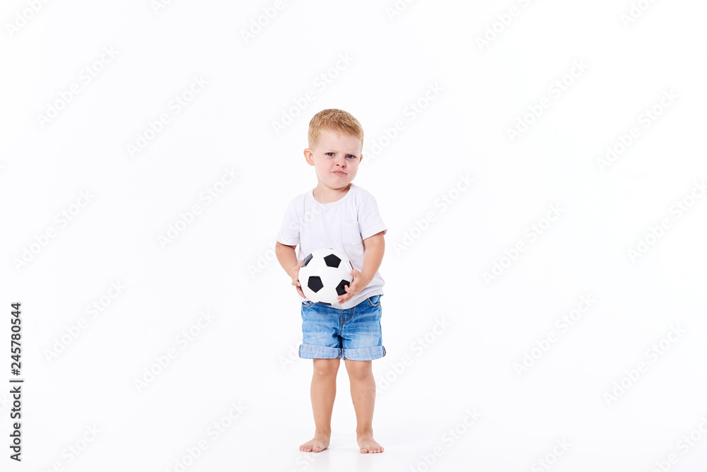 Little cute kid baby boy 3 years old, football fan in white t-shirt playing with soccer ball isolated on white background. lifestyle concept. Copy space for text Little cute kid baby boy 3 years old, football fan in white t-shirt playing with soccer ball isolated on white background. lifestyle concept. Copy space for text