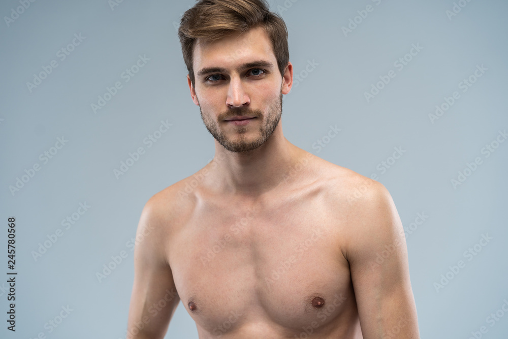 Fototapeta premium portrait of attractive confident concentrated focused seductive guy with ideal face features bearded with stylish trendy hairdress isolated on gray.