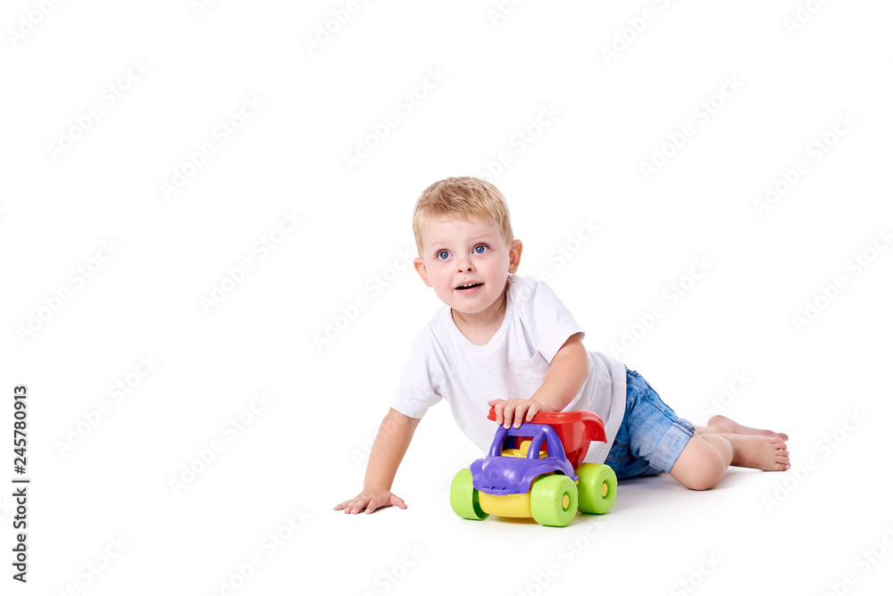 Cute boy plaing with toy car on floor, isolated on white Cute boy plaing with toy car on floor, isolated on white