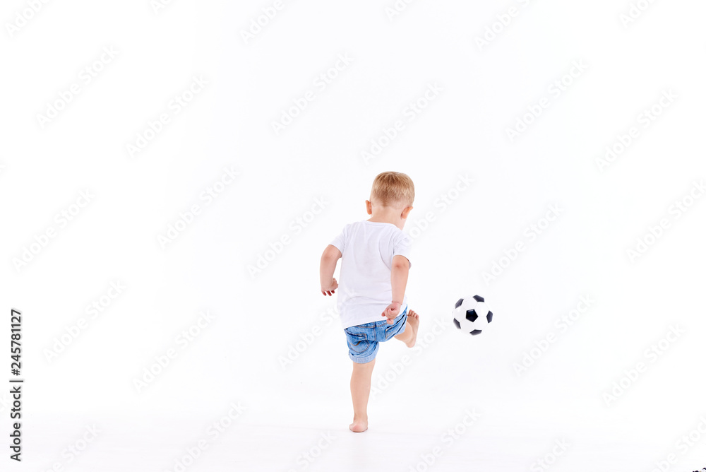 Little cute kid baby boy 3 years old, football fan in white t-shirt playing with soccer ball isolated on white background. lifestyle concept. Copy space for text Little cute kid baby boy 3 years old, football fan in white t-shirt playing with soccer ball isolated on white background. lifestyle concept. Copy space for text