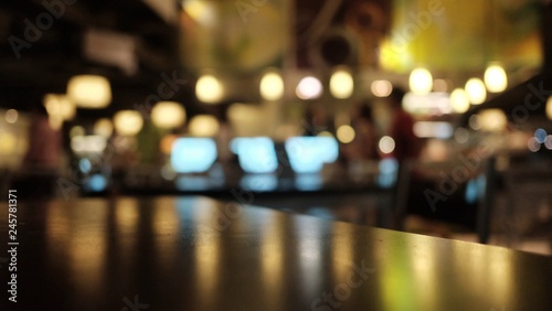 Blurred a wooden dinning table in the room area with warm bokeh light in the dark night 