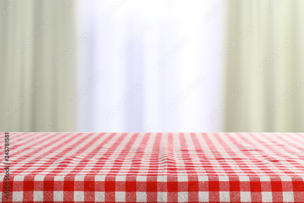 Empty table in room with checkered red napkin on blurred background. Space for design