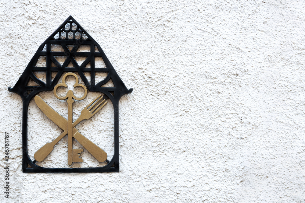 A sign on the wall with the image of the house key knife and fork. A sign on the wall with the image of the house key knife and fork.