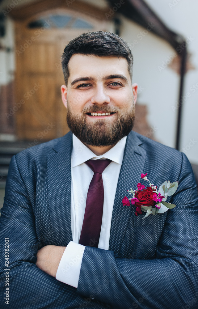 Closeup portrait of a bearded and cheerful groom. Stylish and charismatic bridegroom in blue suit is smiling to the bride not to nature. Wedding photography. Closeup portrait of a bearded and cheerful groom. Stylish and charismatic bridegroom in blue suit is smiling to the bride not to nature. Wedding photography.