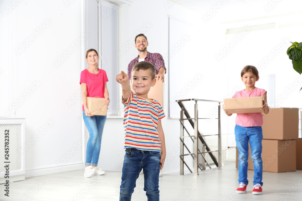 Fototapeta premium Happy family with moving boxes in their new house