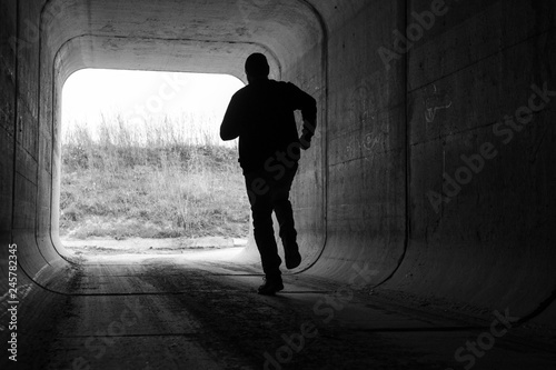man running through dark tunnel escaping