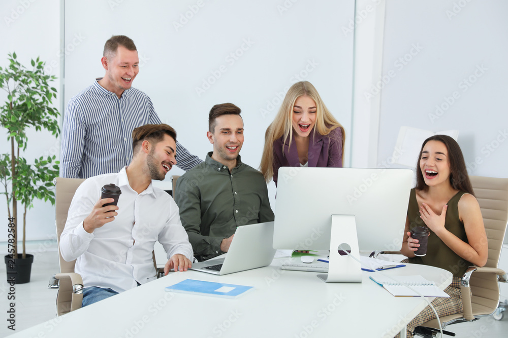 Group of colleagues laughing together in office Group of colleagues laughing together in office