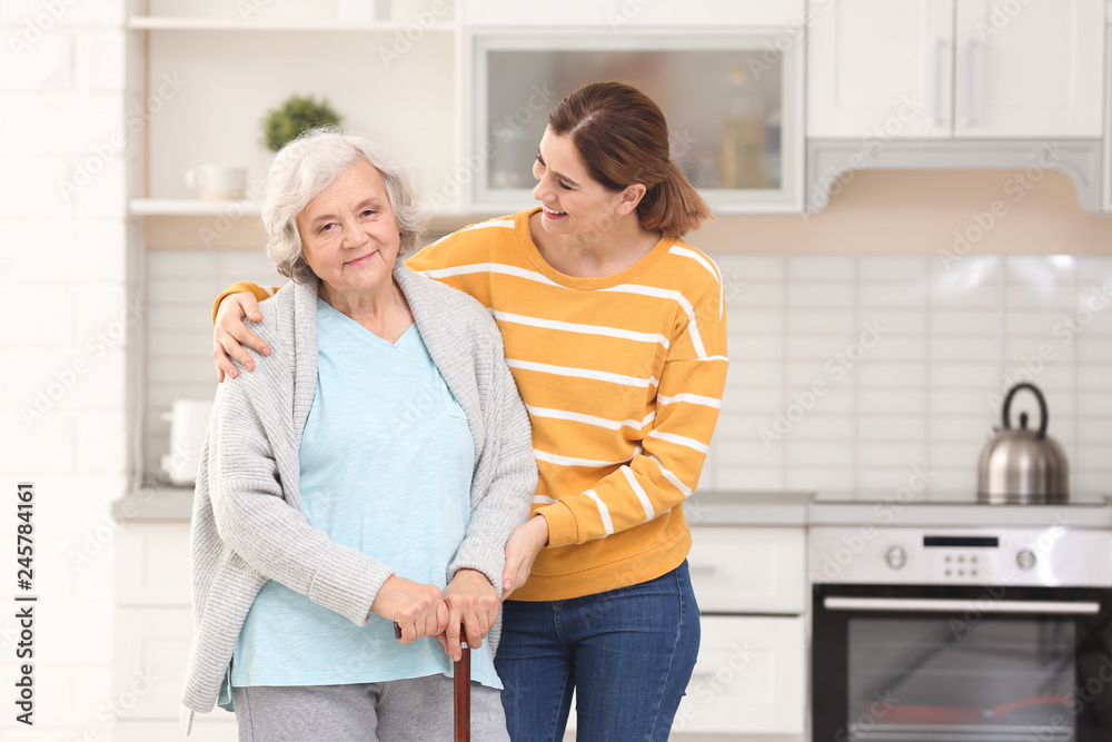 Elderly woman with female caregiver in kitchen. Space for text Elderly woman with female caregiver in kitchen. Space for text