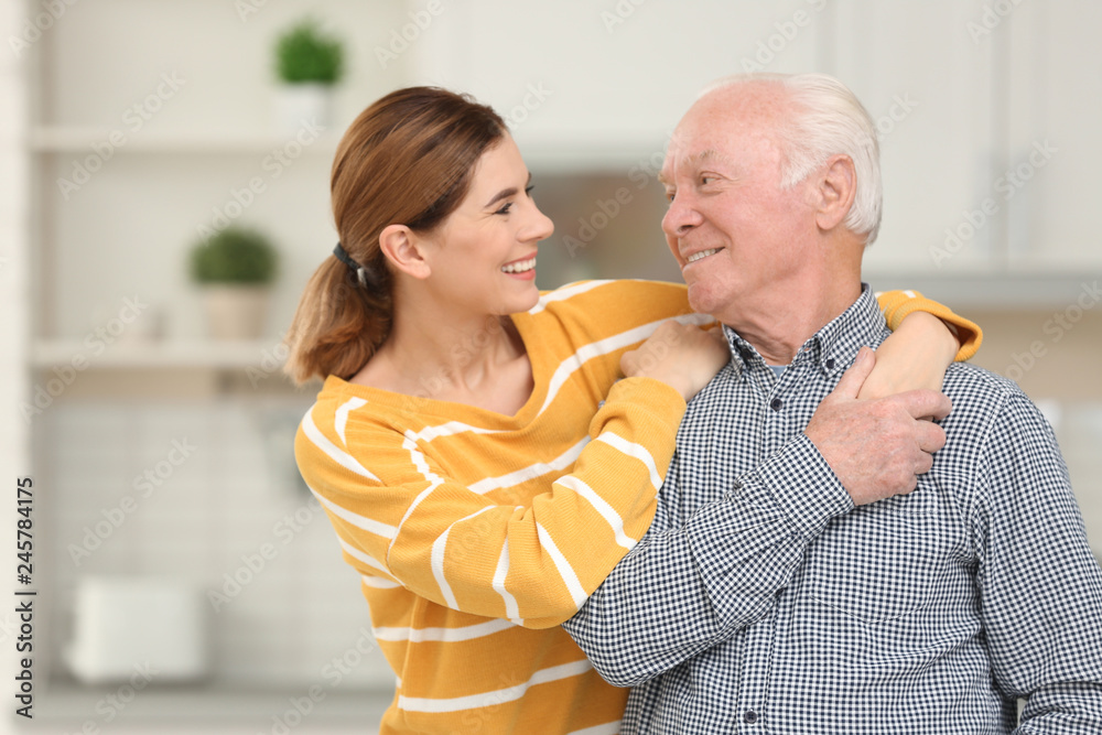Elderly man with female caregiver in kitchen Elderly man with female caregiver in kitchen