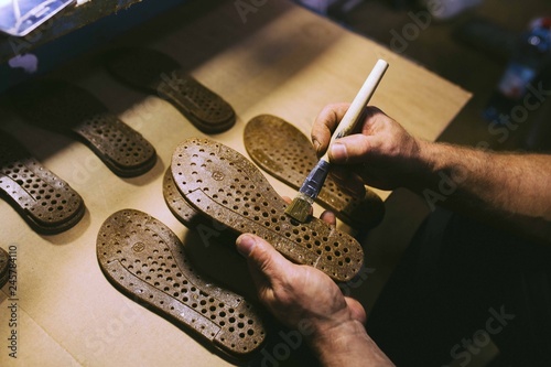 Hands making shoes. Making shoes manual. Shoemaker sitting in workshop making shoes. Footwear manufacture. Shoes factory.