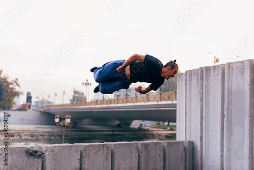 Parkour guy in action while exercising parkour at urban place.