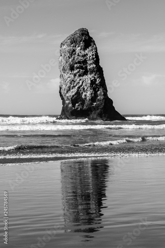 Waves crashing on vertical rocks protruding in Cannon Beach, Oregon, USA.