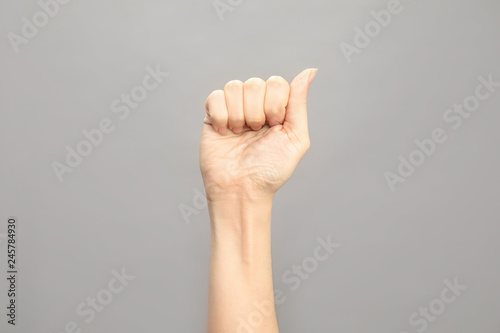 Woman showing A letter on grey background  closeup. Sign language