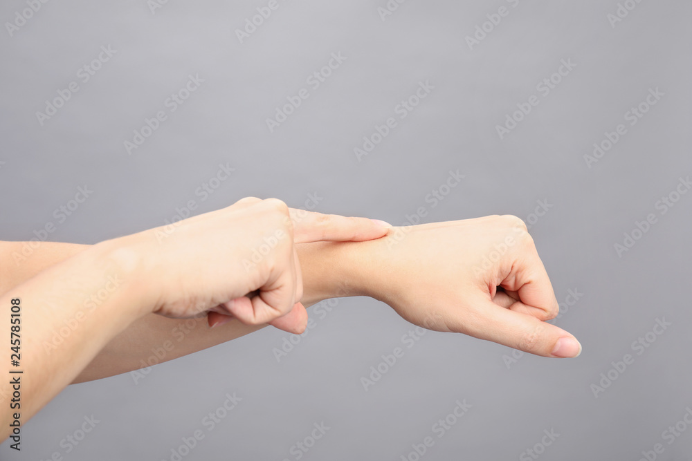 Woman showing word time on grey background, closeup. Sign language