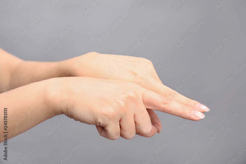 Woman showing word same on grey background, closeup. Sign language Woman showing word same on grey background, closeup. Sign language