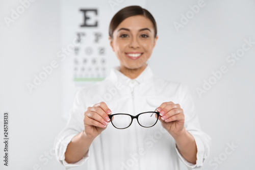 Fototapeta Naklejka Na Ścianę i Meble -  Female ophthalmologist with new eyeglasses in clinic