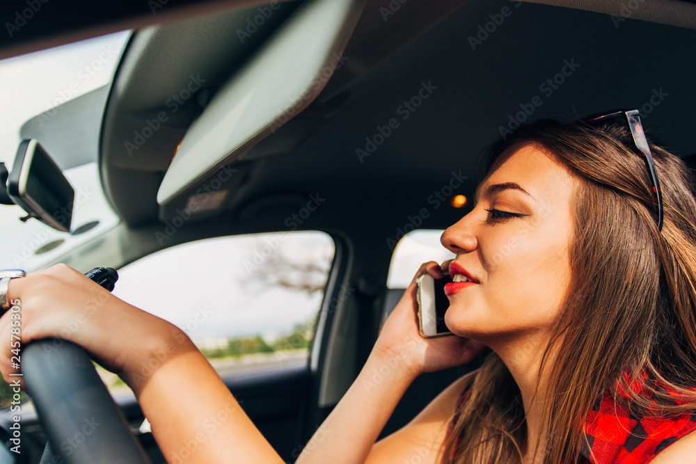 Businesswoman talking on the phone in the car while driving reckless
