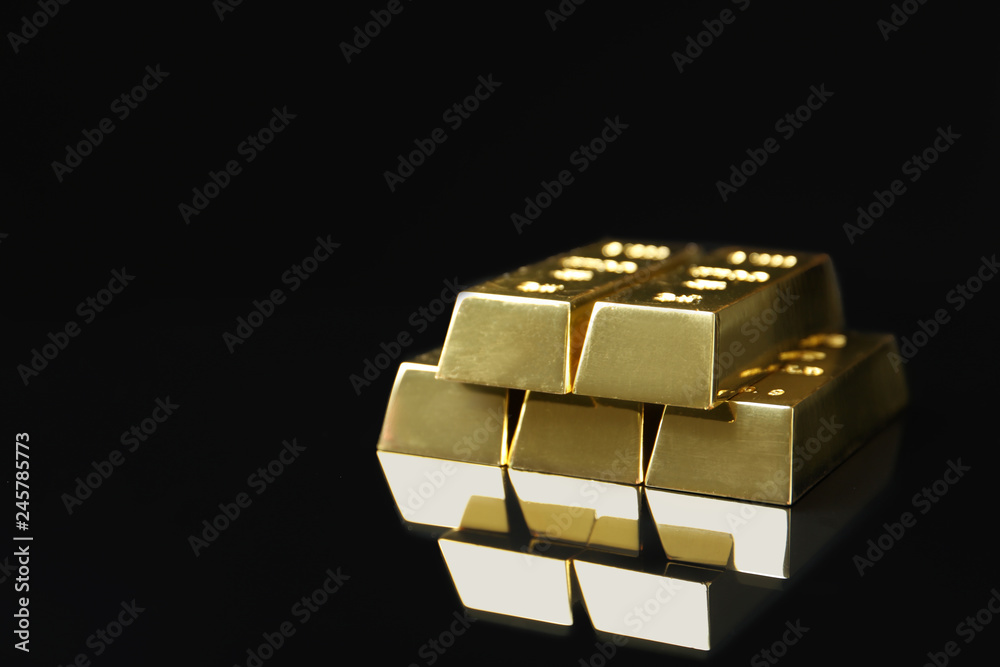 Shiny gold bars on black background. Space for text