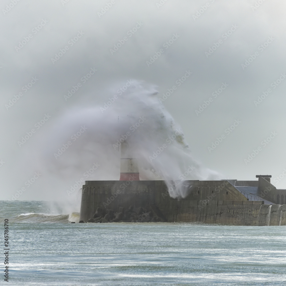 Stunning dangerous high waves crashing over harbor wall during windy Winter storm at Newhaven on English coast
