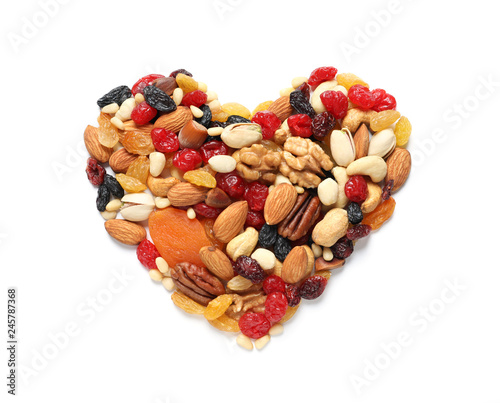 Heart made of dried fruits and nuts on white background, top view