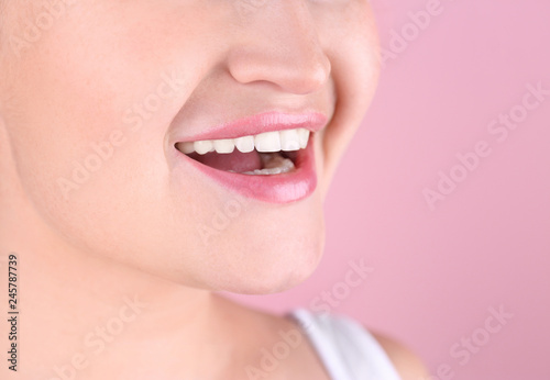 Young woman with beautiful smile on color background, closeup. Space for text