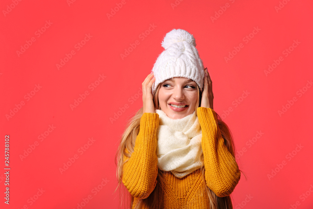 Portrait of emotional young woman in stylish hat, sweater and scarf on color background. Winter atmosphere Portrait of emotional young woman in stylish hat, sweater and scarf on color background. Winter atmosphere