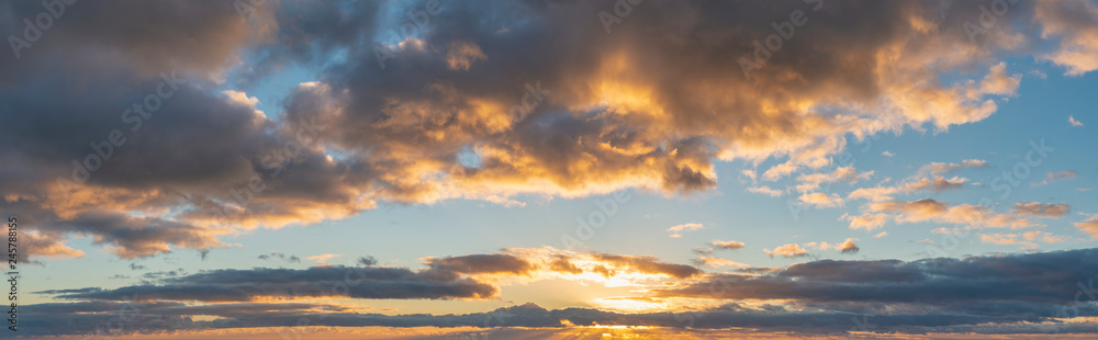 Beautiful colorful vibrant golden hour sunset skyscape with cloud formation and setting sun