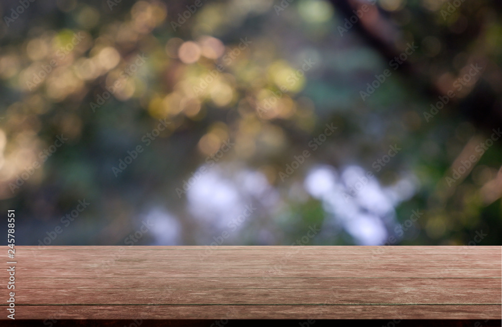 Empty wooden table in front of abstract blurred green of garden and trees .background. For montage product display or design key visual layout - Image. Empty wooden table in front of abstract blurred green of garden and trees .background. For montage product display or design key visual layout - Image.