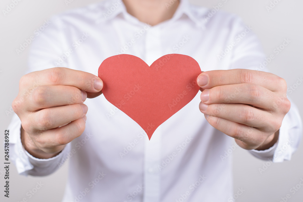 Cropped close-up photo portrait of cheerful handsome dream dreamy nice lovely cute tender glad positive smiling guy holding heart near chest isolated grey background Cropped close-up photo portrait of cheerful handsome dream dreamy nice lovely cute tender glad positive smiling guy holding heart near chest isolated grey background