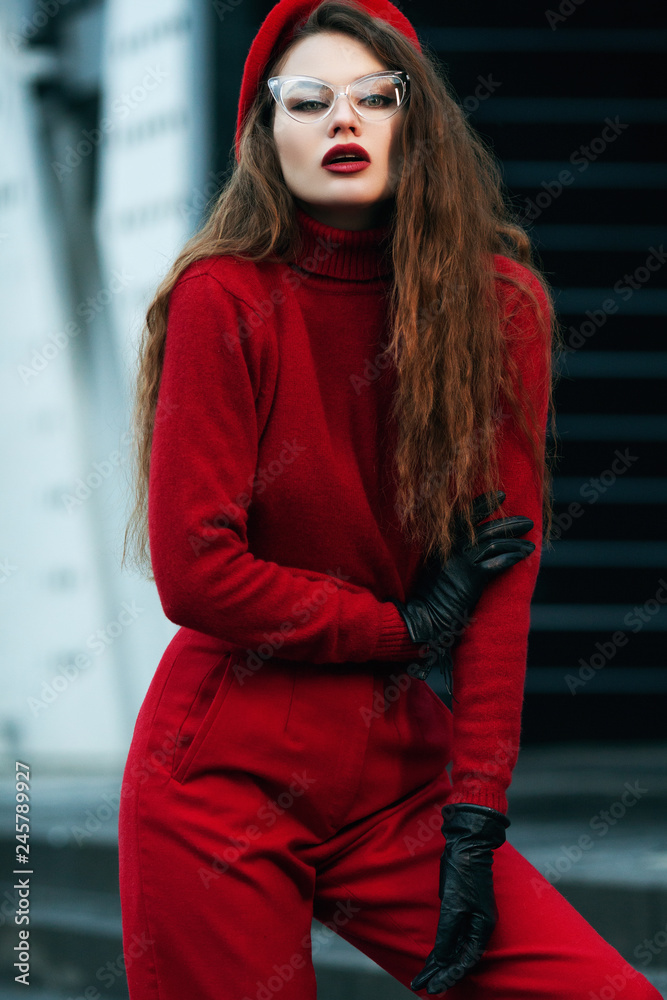 Outdoor portrait of young beautiful fashionable woman posing in street.  Total red look. Model wearing red cashmere turtleneck sweater, beret,  pants, gloves, cat eye glasses. Female fashion concept Stock-Foto | Adobe  Stock