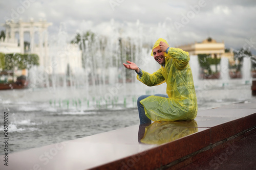 Fototapeta Naklejka Na Ścianę i Meble -  A man in a raincoat on a rainy day