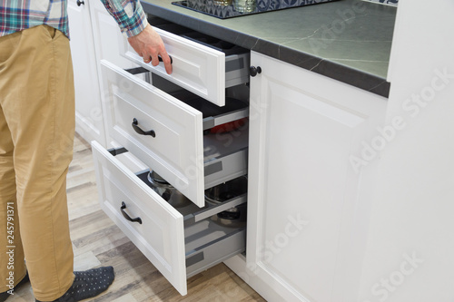 Men opensing white kitchen drawers photo